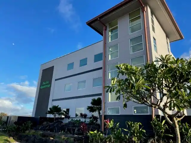 Front of the Pacific AquaGroup building on Lauwiliwili Street with plumeria in front