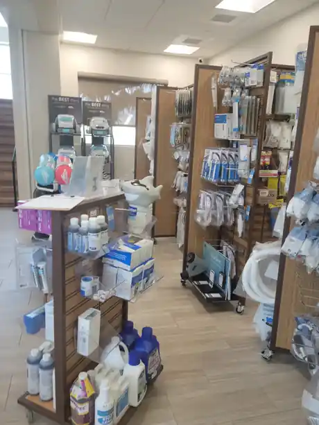 Pool-supply shelves inside the Kapolei store with pumps, filters and Maytronics robotic cleaners