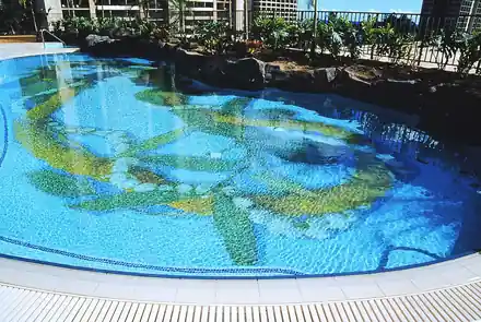 Freeform Hilton Hawaiian Village pool with a sea-green mosaic on the floor and rockwork on the far edge