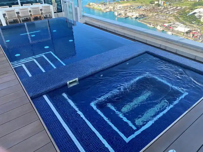 Rooftop residential pool and spa at Waiea, Honolulu, in deep blue tile with white step bands